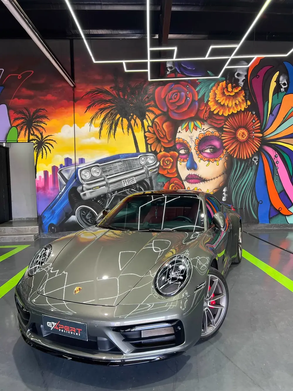 Porsche 911 Carrera cinza em frente ao mural